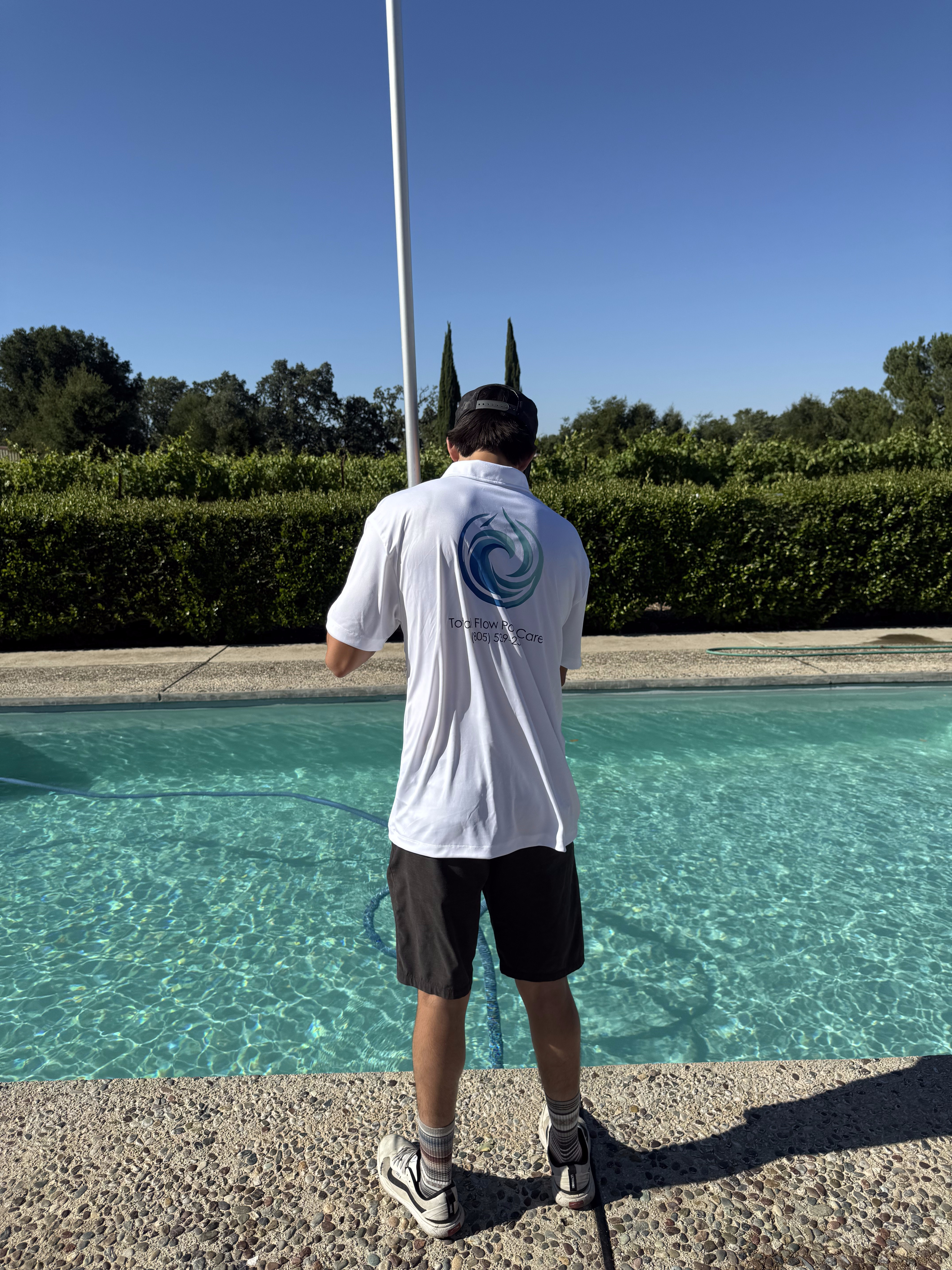 Total Flow Pool Care technician servicing a pool